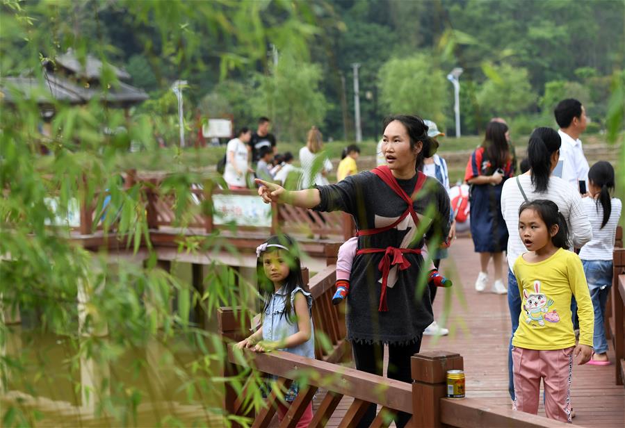 4月19日,在广西南宁市青秀区南阳镇施厚村古岳坡,游客在观看米粉制作。