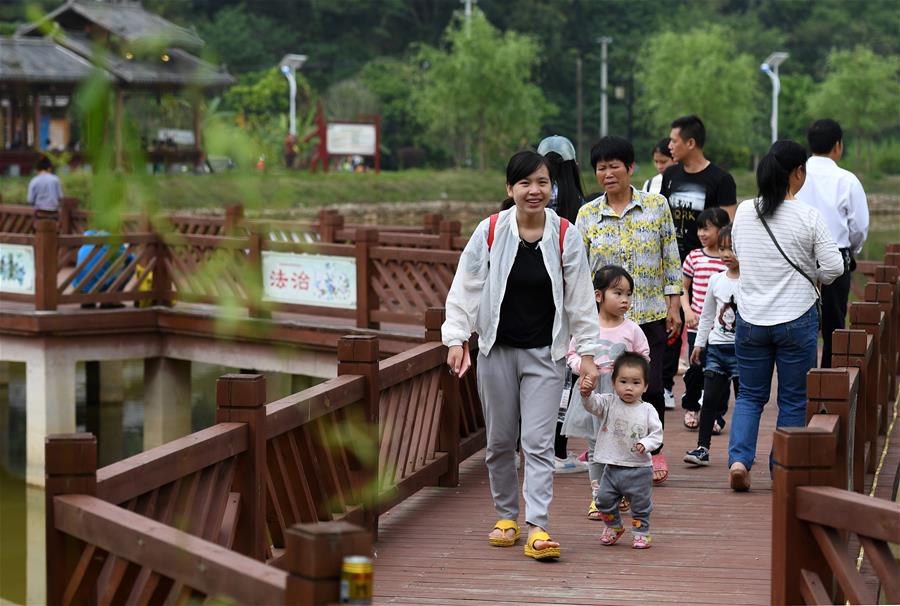 4月19日,在广西南宁市青秀区南阳镇施厚村古岳坡,游客在观看米粉制作。