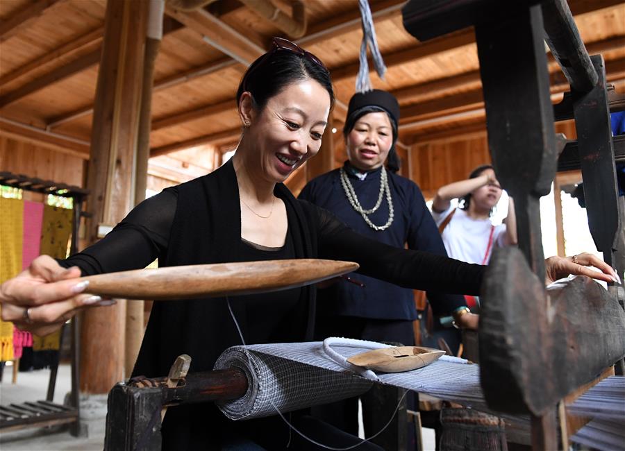 4月19日,在广西南宁市青秀区南阳镇施厚村古岳坡,游客在观看米粉制作。