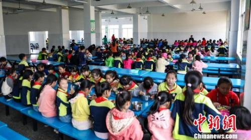 资料图:小学学生在食堂吃午餐。 周潇男 摄 资料图:小学学生在食堂吃午餐。 周潇男 摄