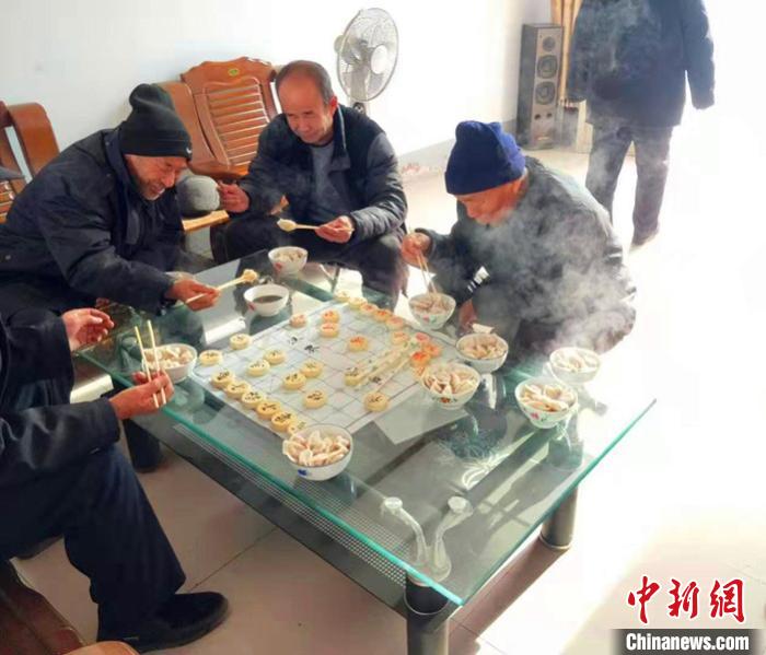在平乡县柴口村的幸福小院里,老人在一边下棋一边吃饺子。 李铁锤 摄 在平乡县柴口村的幸福小院里,老人在一边下棋一边吃饺子。 李铁锤 摄